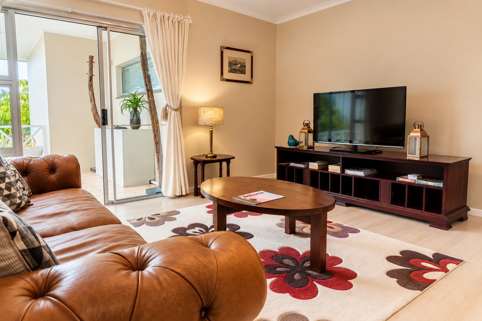 Sunbird Chalet lounge with a leather sofa, coffee table and a flat-screen TV on a wooden console