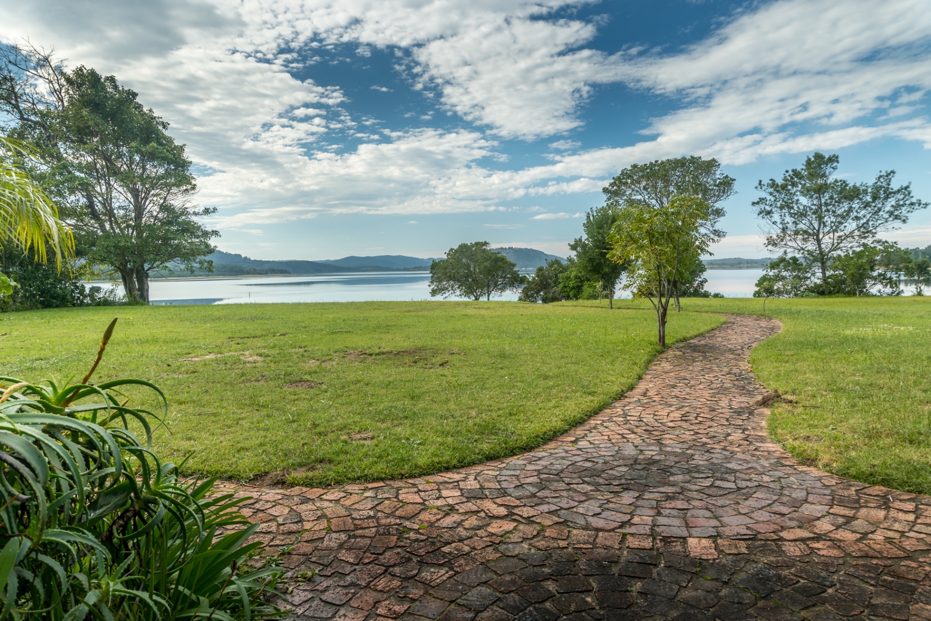 Stone garden path leading toward Swartvlei Lake from Sunbird Chalet