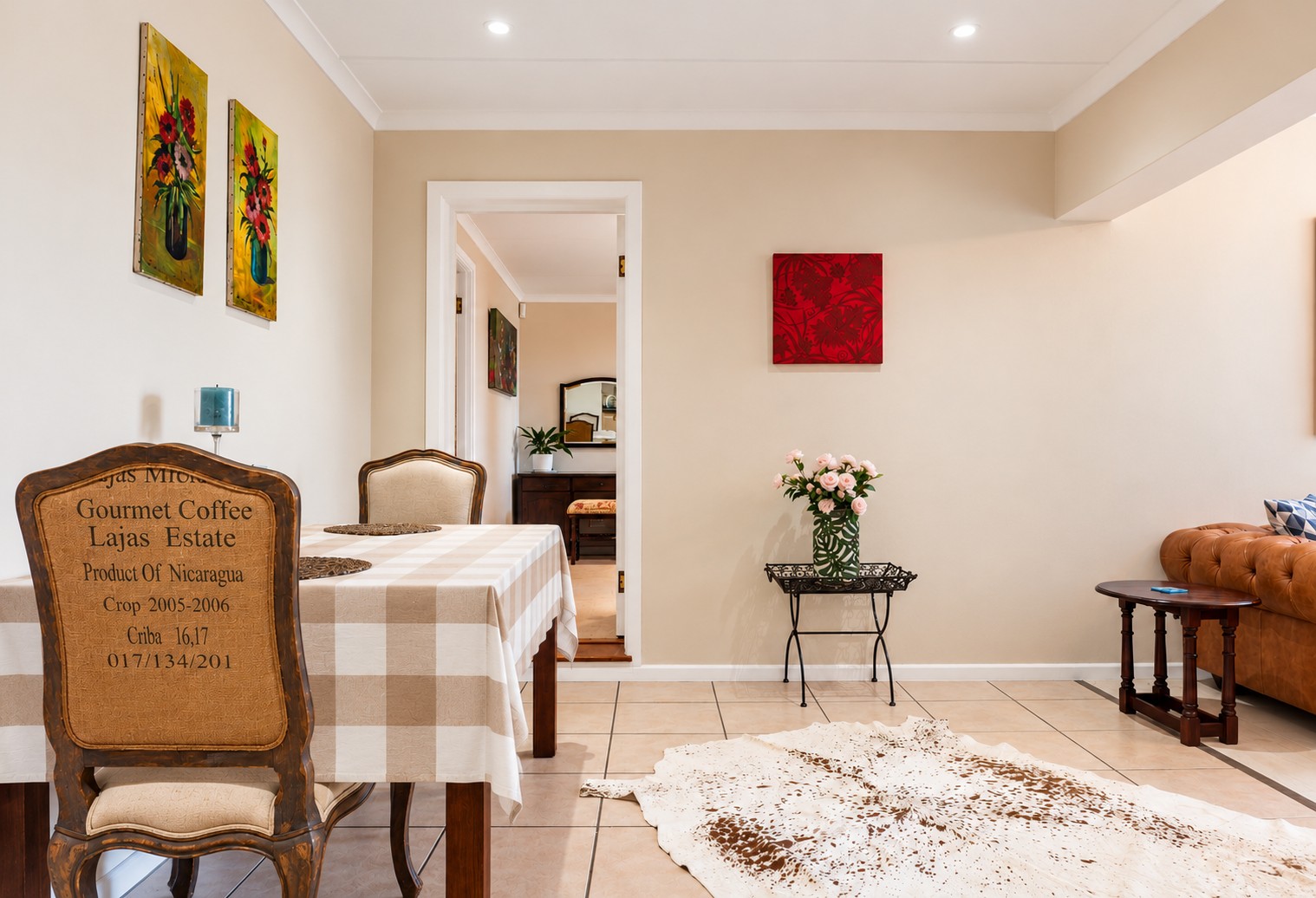 Dining area at Sunbird Chalet with a wooden table, patterned chairs and an open doorway