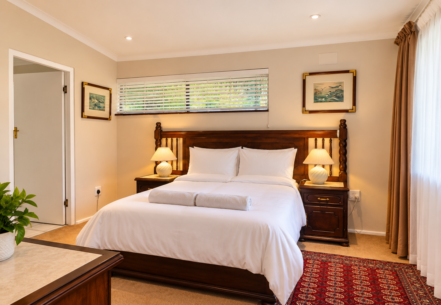 Second bedroom at Fish Eagle Chalet with a wooden bed, white linen, two bedside lamps and a patterned rug